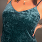 Teal velvet dress worn by a woman on a plain background