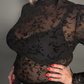 Black floral lace top worn by a woman against a neutral background