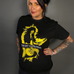 Woman wearing a black t-shirt with a yellow graphic design on a gray background